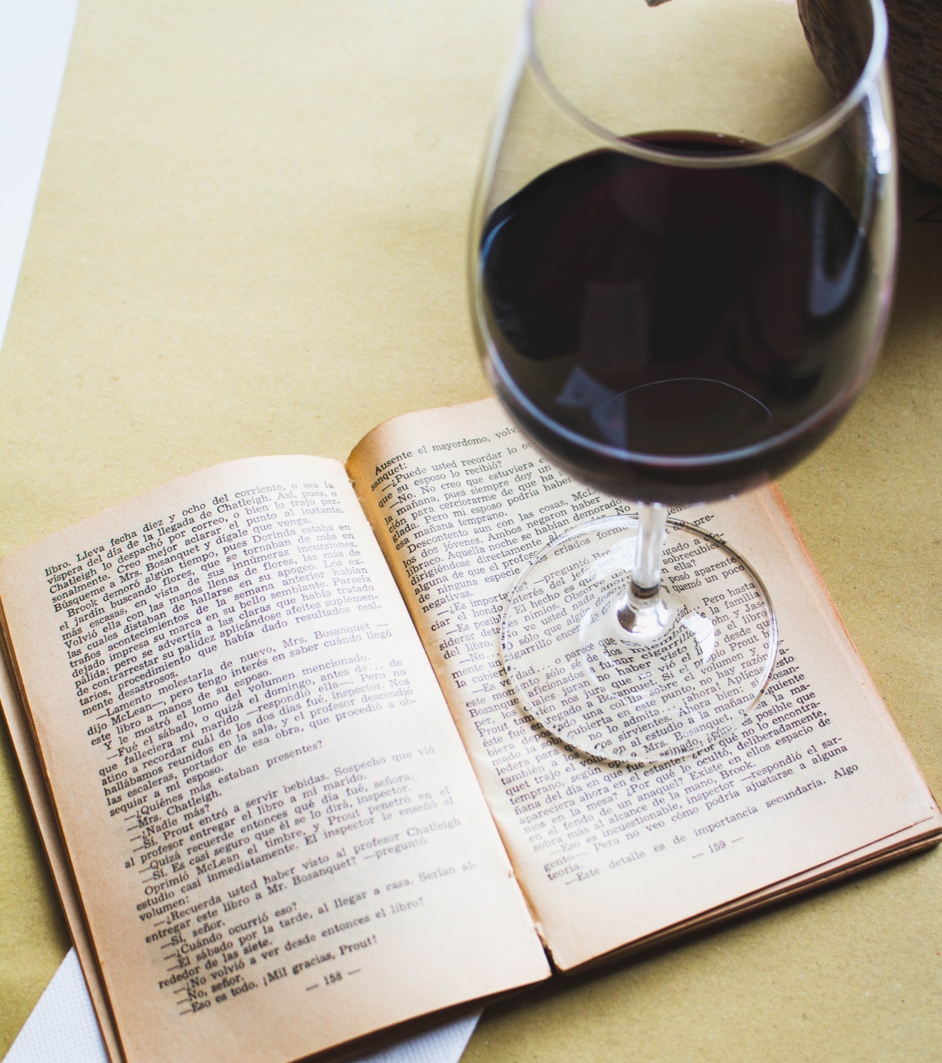 Libro abierto y copa de vino en una cata de libros